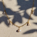 Gold necklace with pearls on a textured fabric background