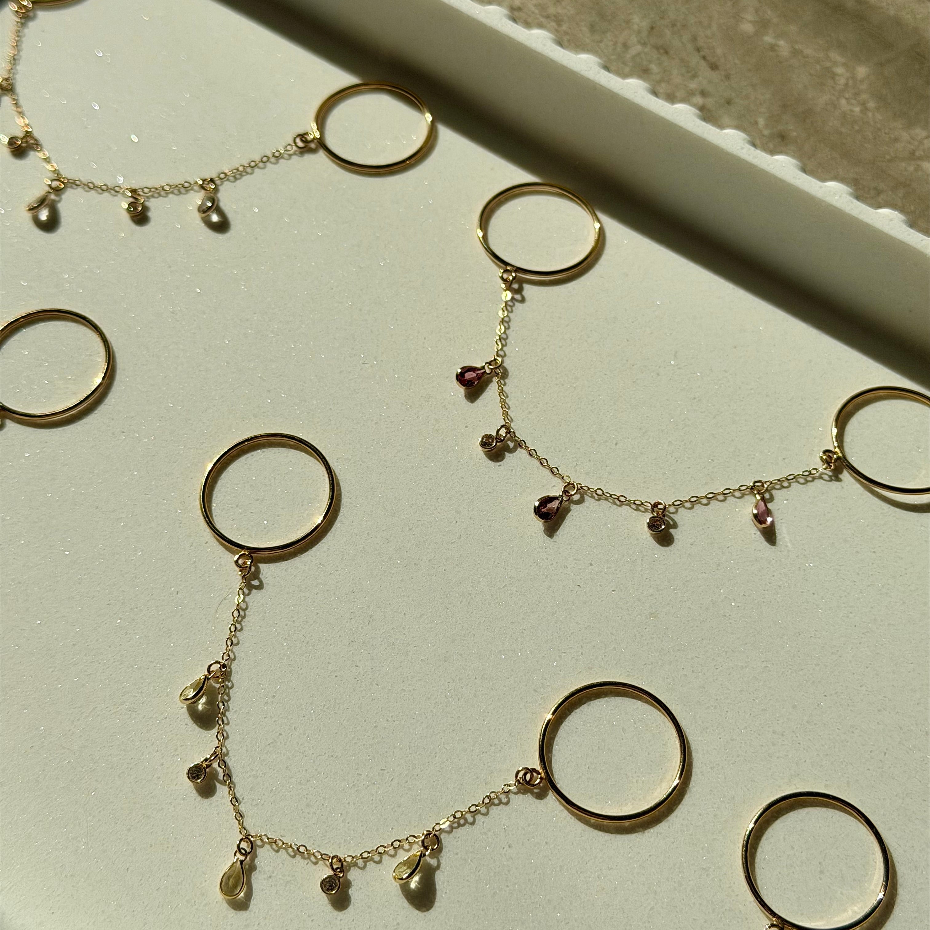 Gold necklaces with circular pendants on a white surface