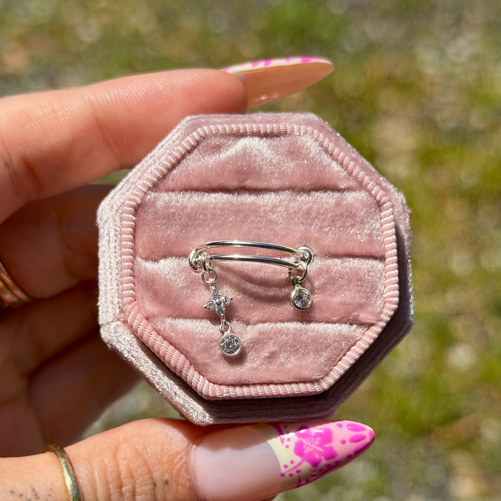 Pink velvet jewelry box with rings held by a hand outdoors