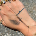 Hand with gold rings and bracelets, featuring a tattoo on the palm.