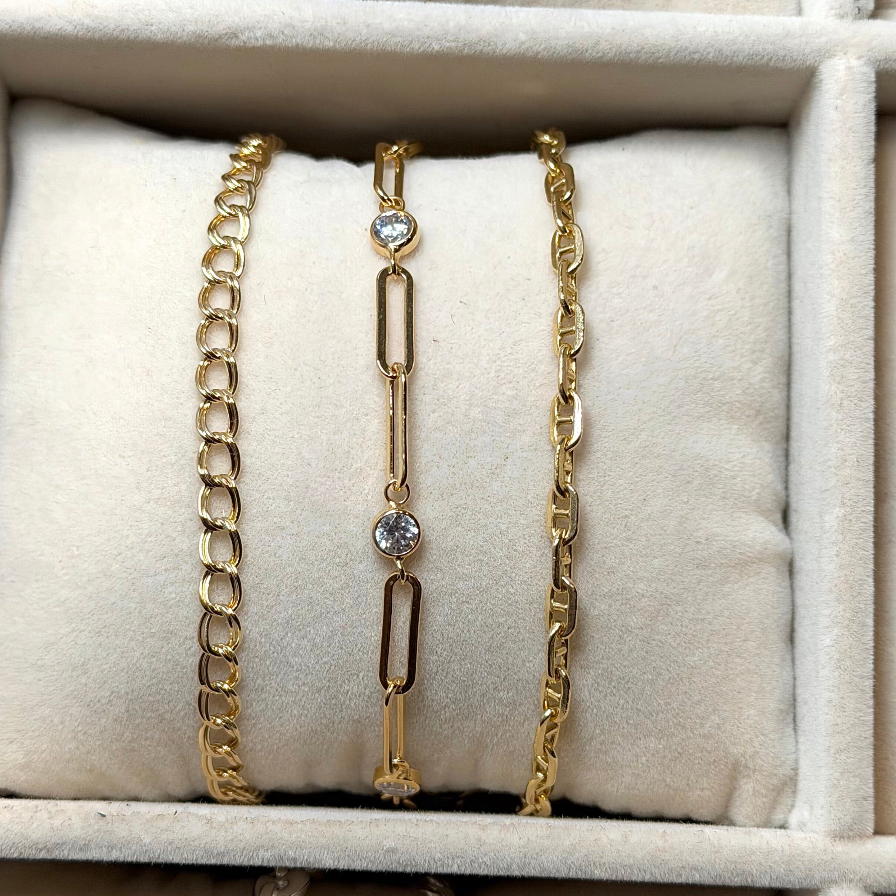 Gold and silver bracelets on a beige jewelry display box