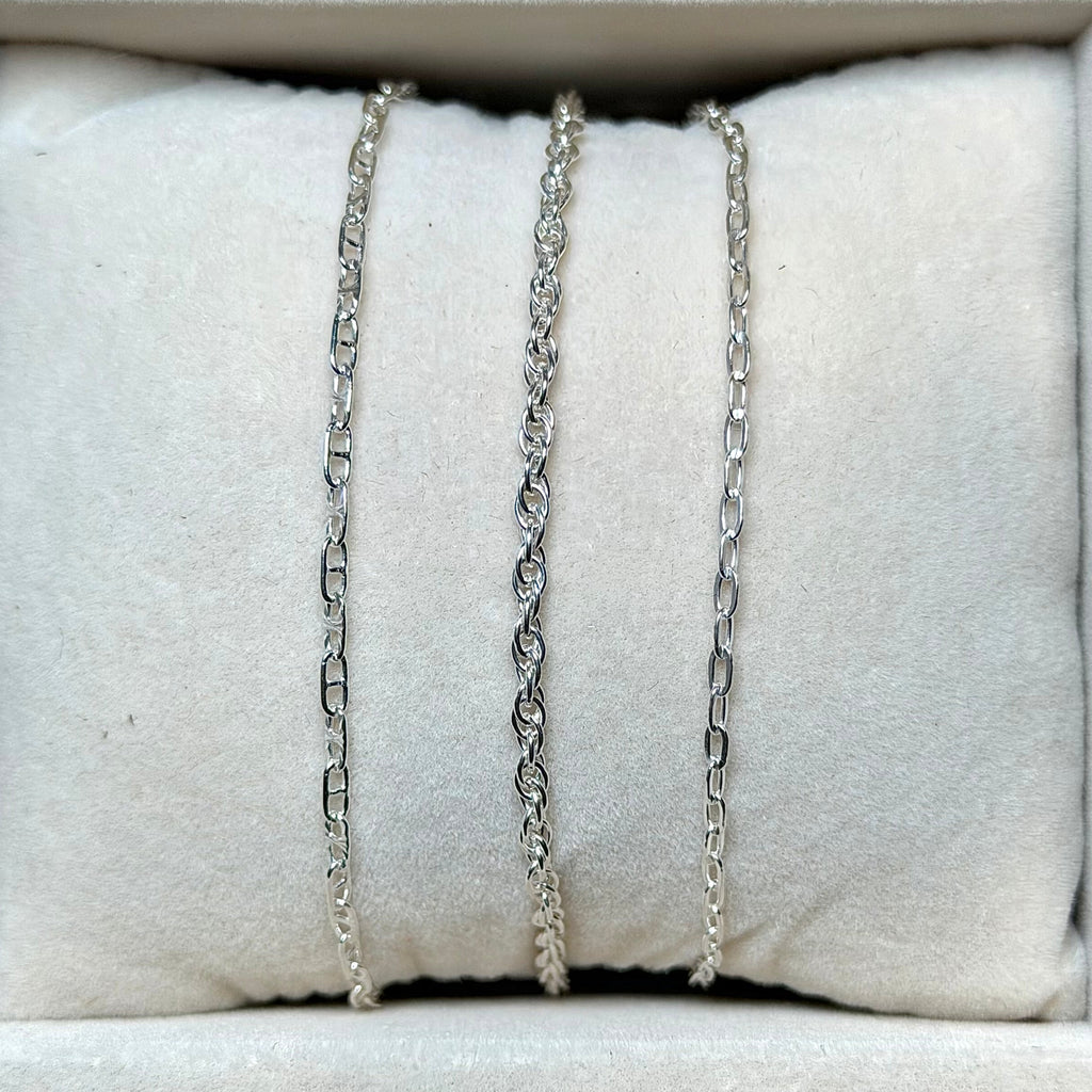 Necklaces displayed on a white jewelry display with a neutral background