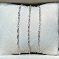 Necklaces displayed on a white jewelry display with a neutral background