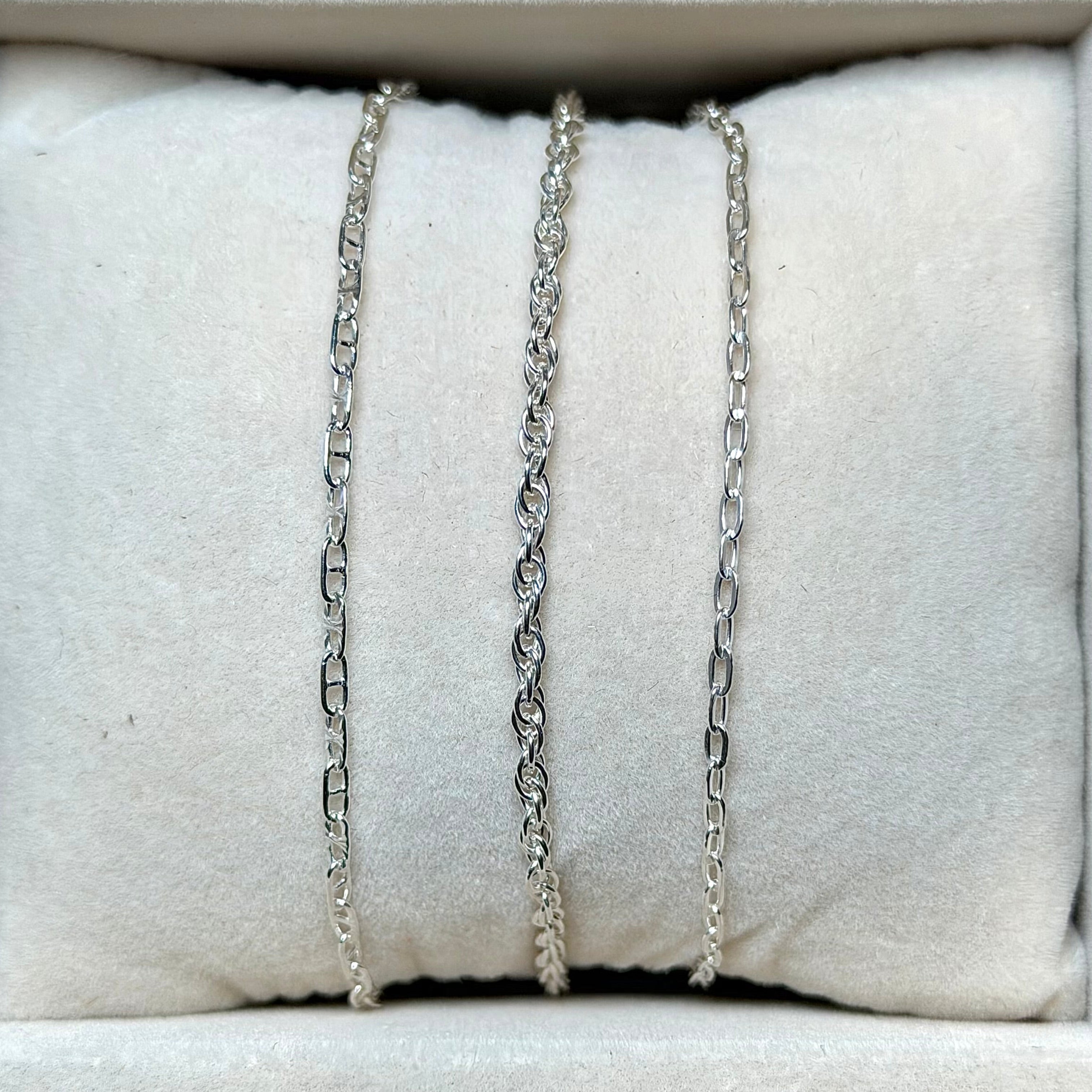 Necklaces displayed on a white jewelry display with a neutral background
