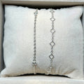 Silver chain necklace displayed on a cushioned surface with a neutral background