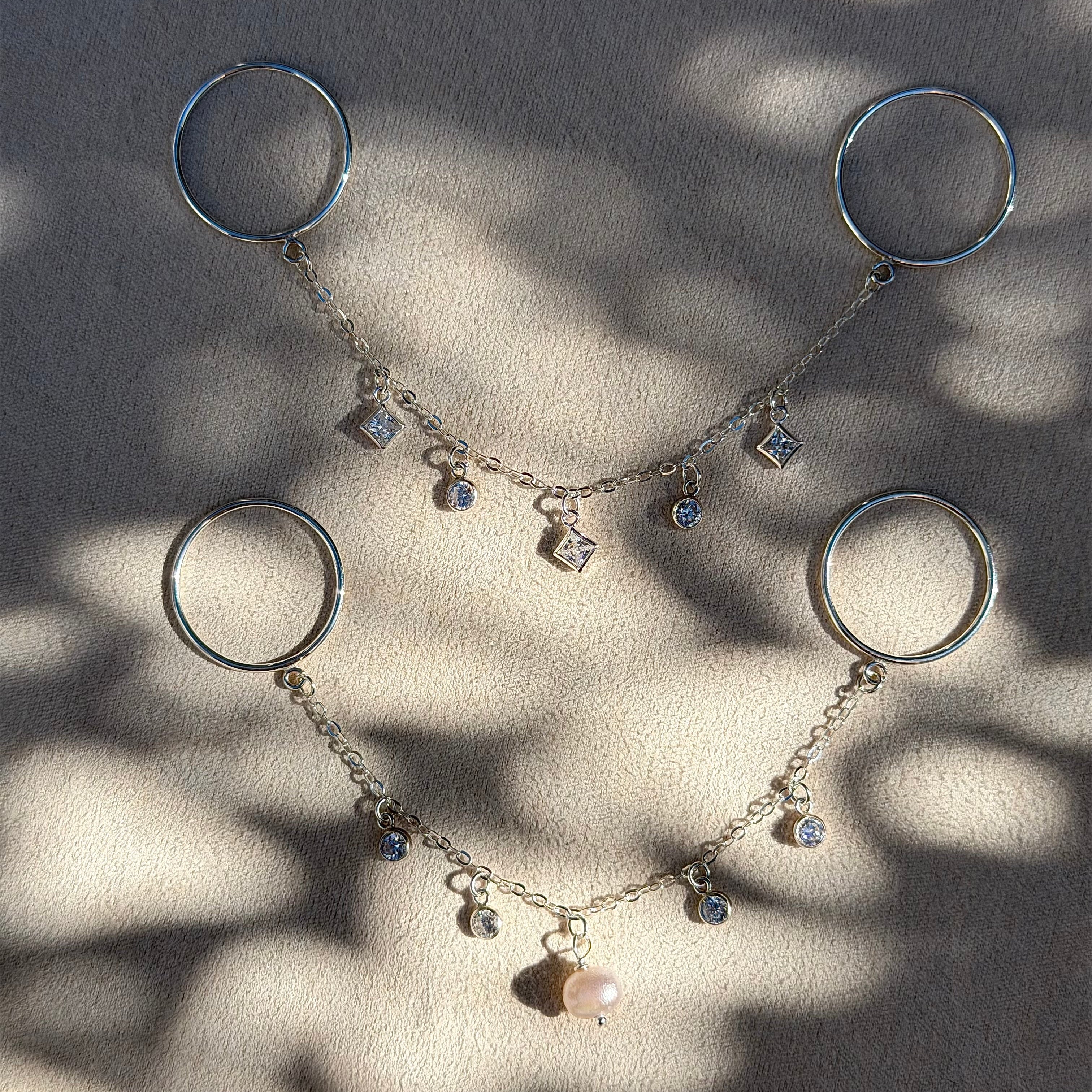 Silver bracelet with circular charms on a textured surface