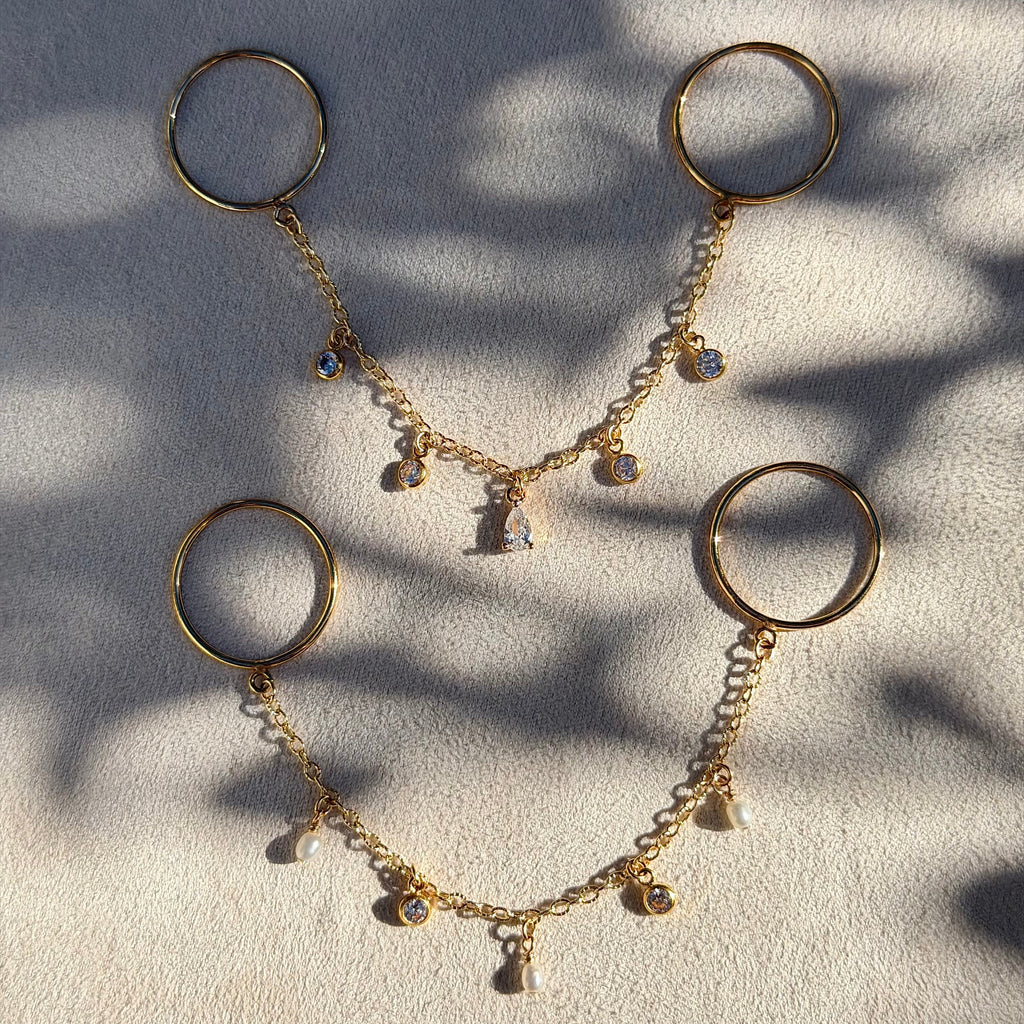 Gold necklace with circular pendants on a textured surface