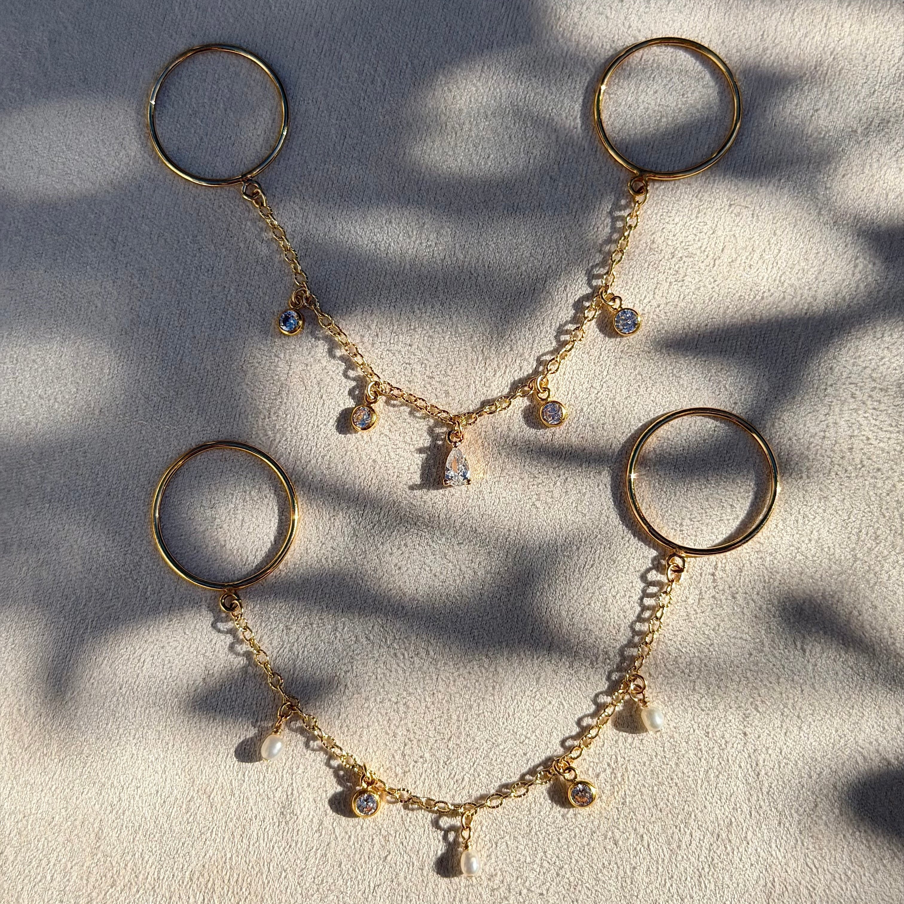 Gold necklace with circular pendants on a textured surface