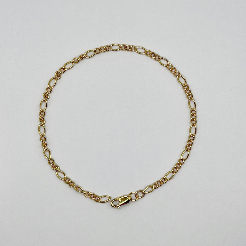 Gold chain bracelet on a light gray background
