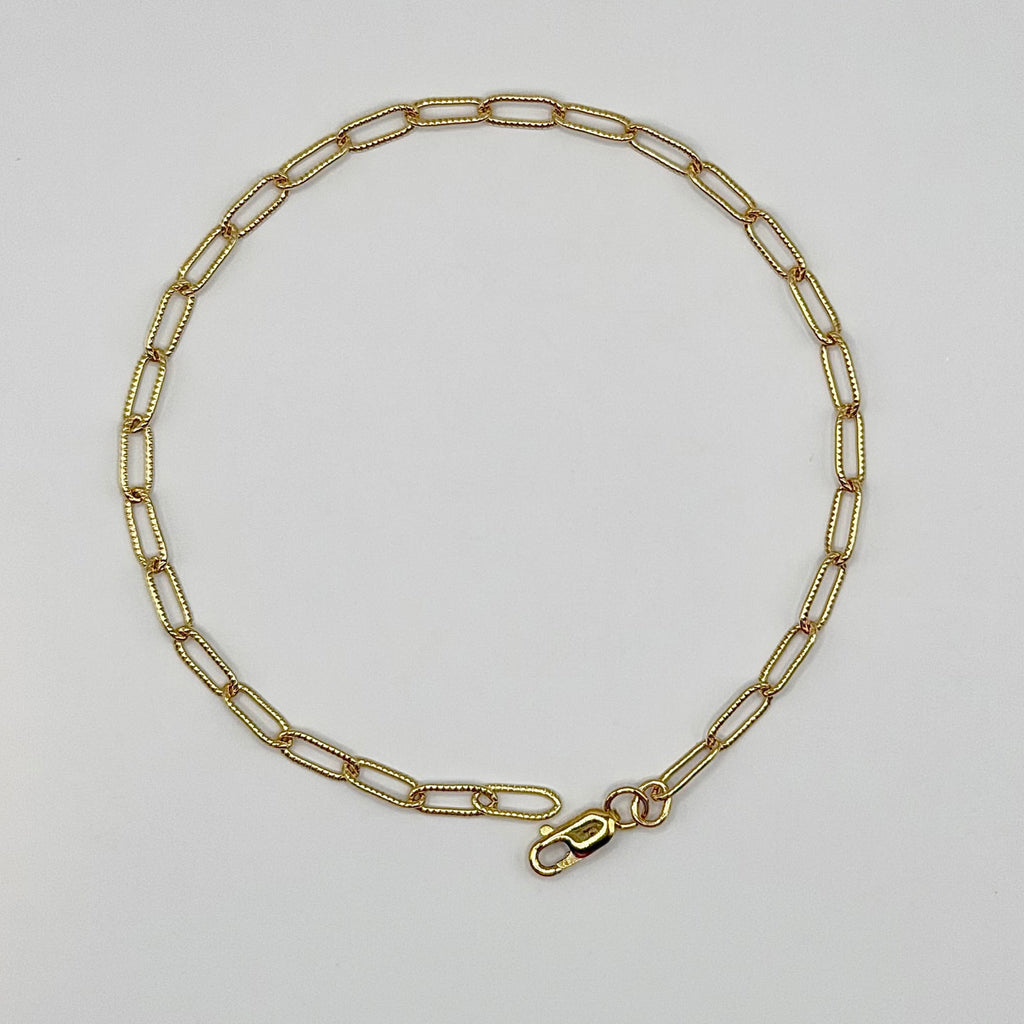 Gold chain necklace on a light gray background