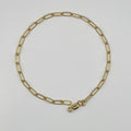 Gold chain necklace on a light gray background
