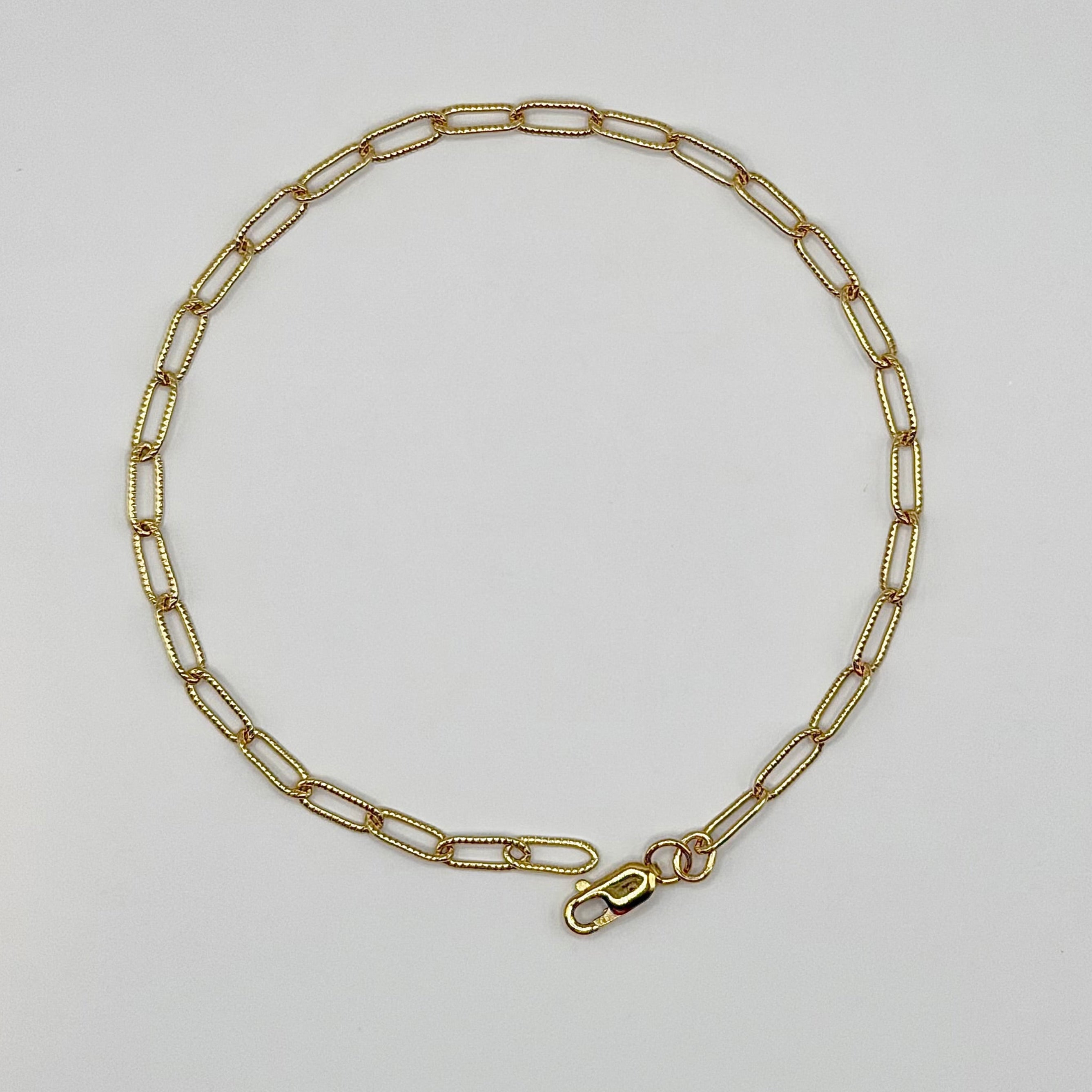 Gold chain necklace on a light gray background