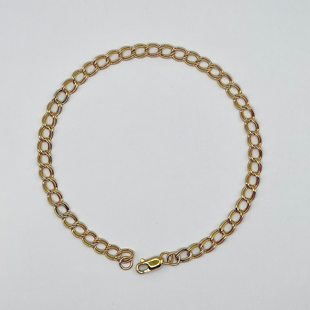 Gold chain necklace on a light gray background