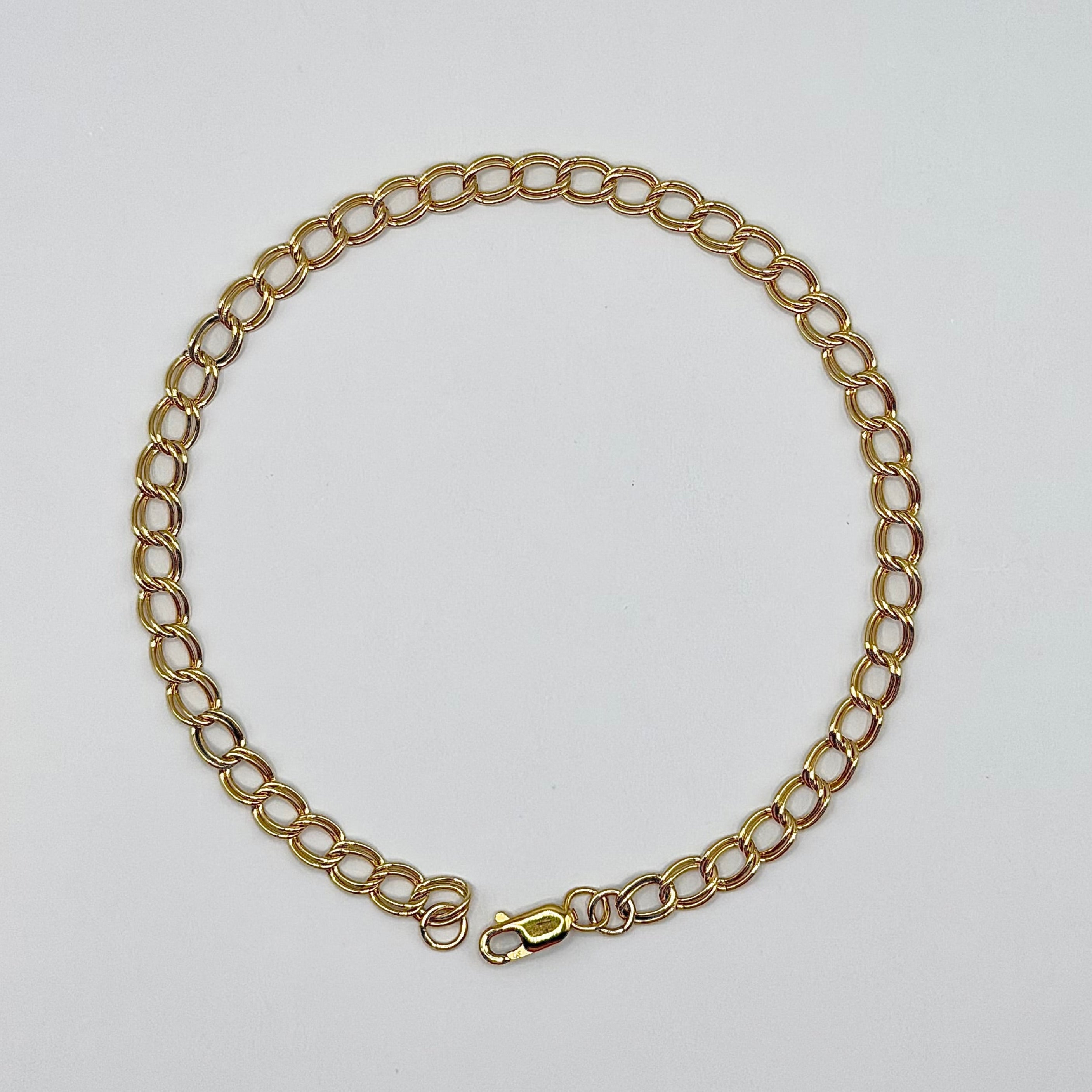 Gold chain necklace on a light gray background