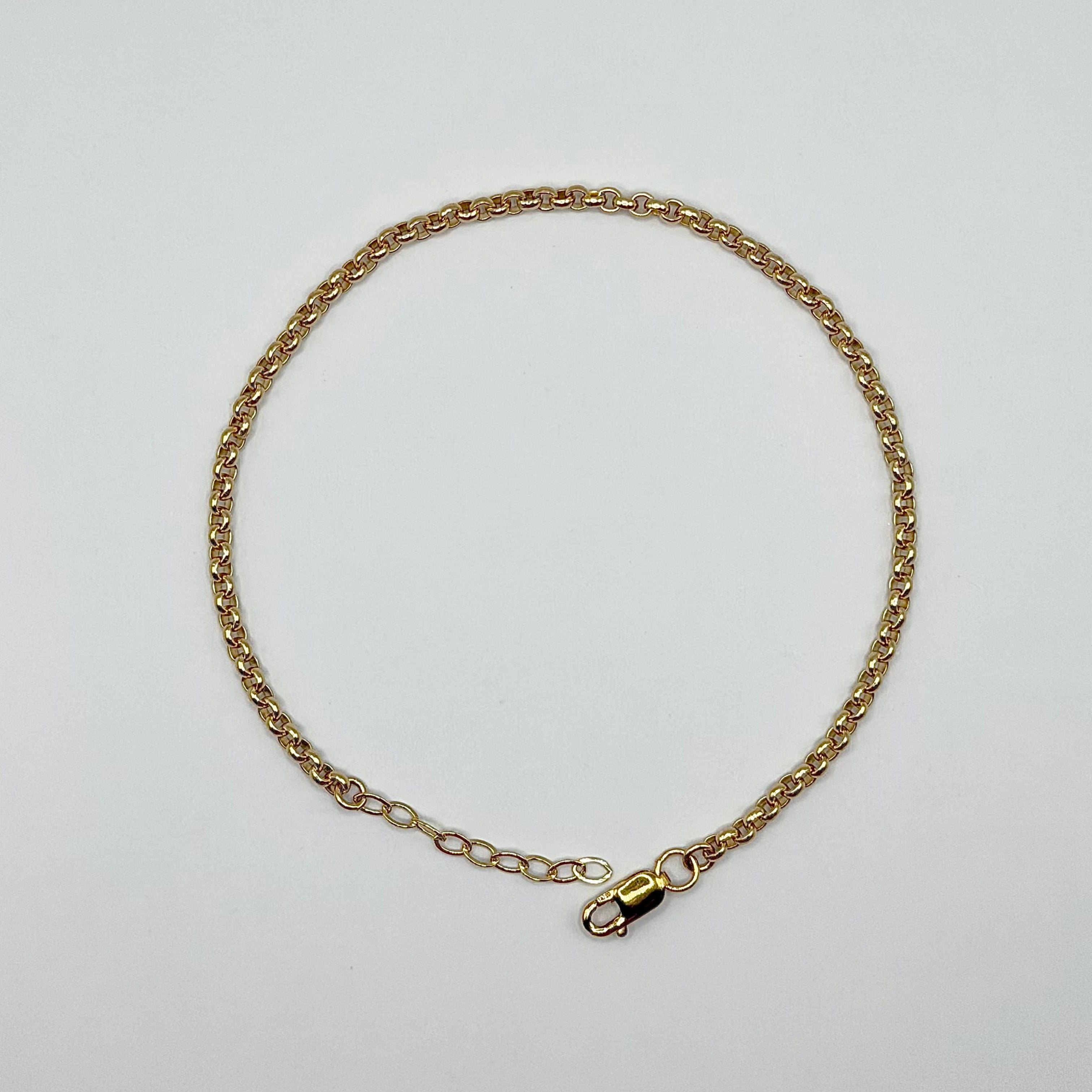 Gold chain necklace on a light gray background
