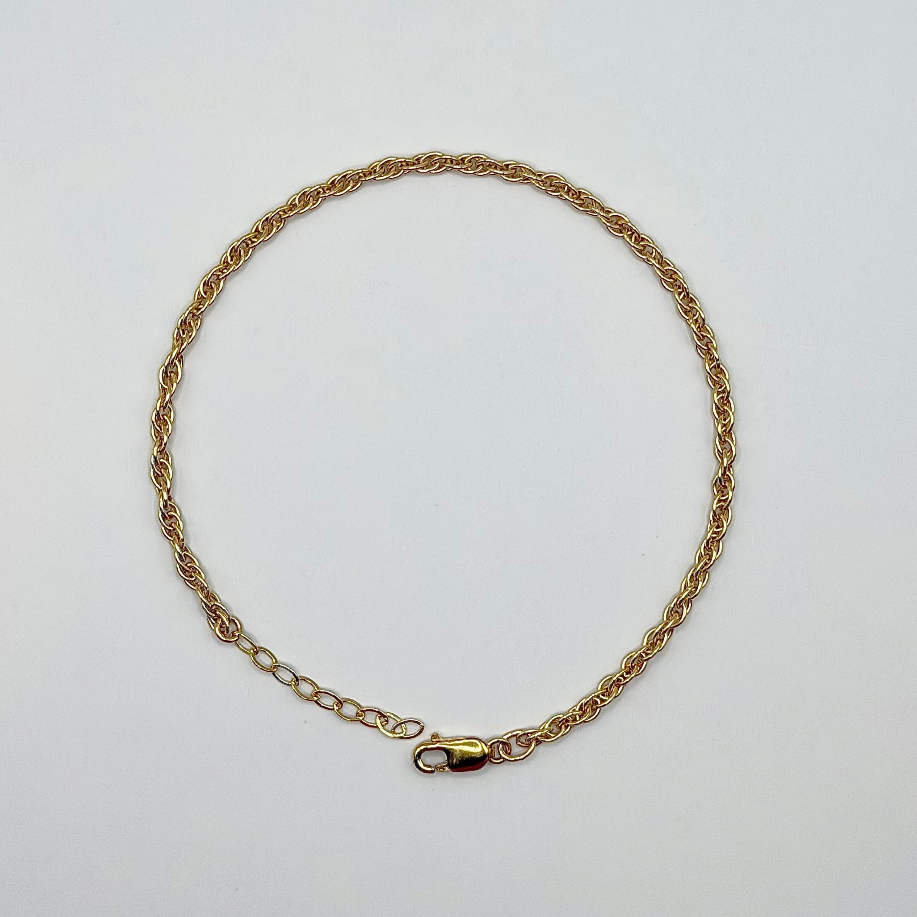 Gold chain necklace on a light gray background