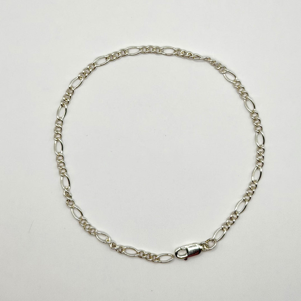Silver chain necklace on a light gray background