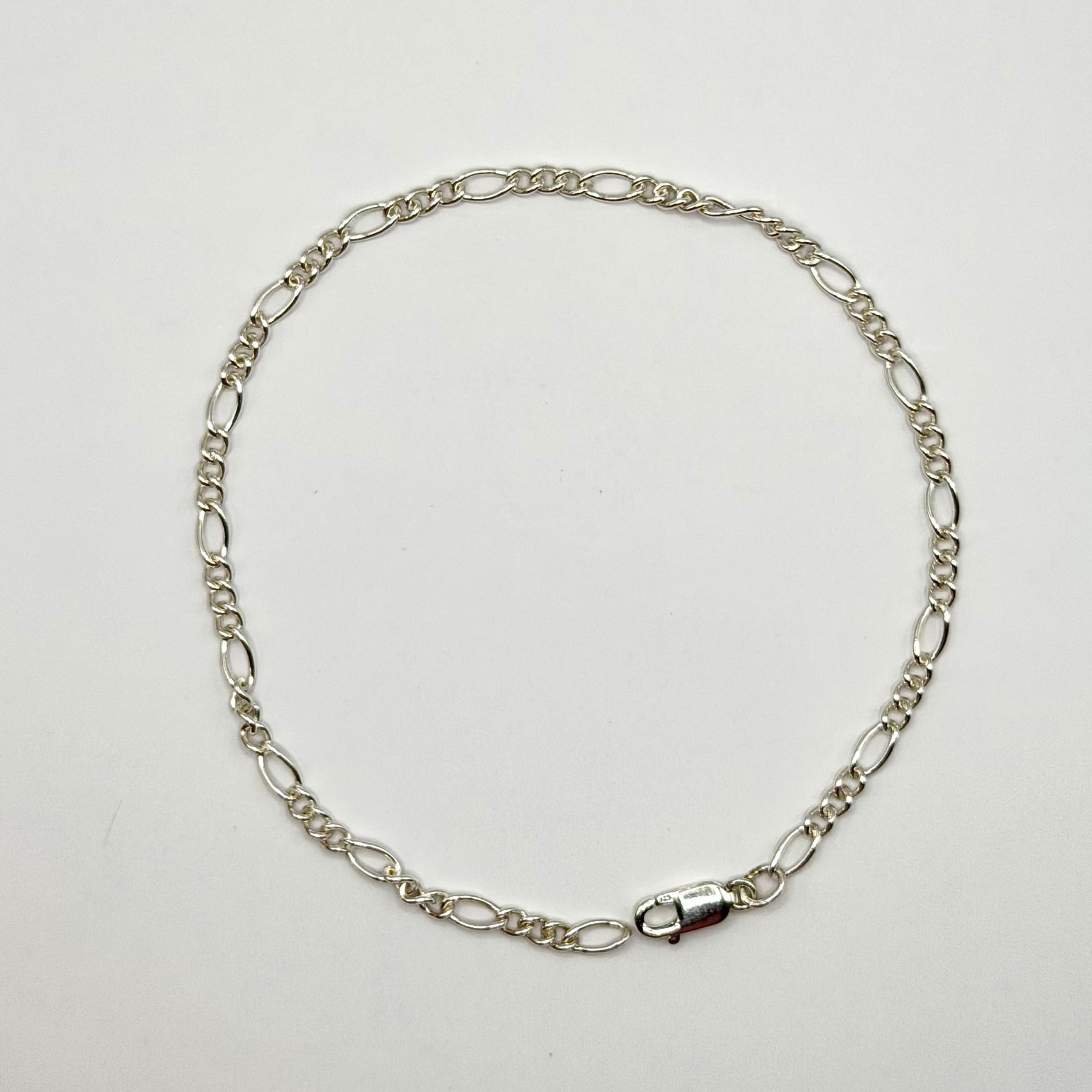 Silver chain necklace on a light gray background
