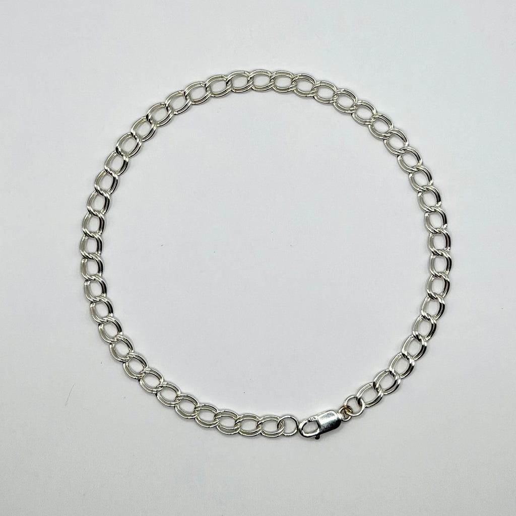 Silver chain bracelet on a light gray background