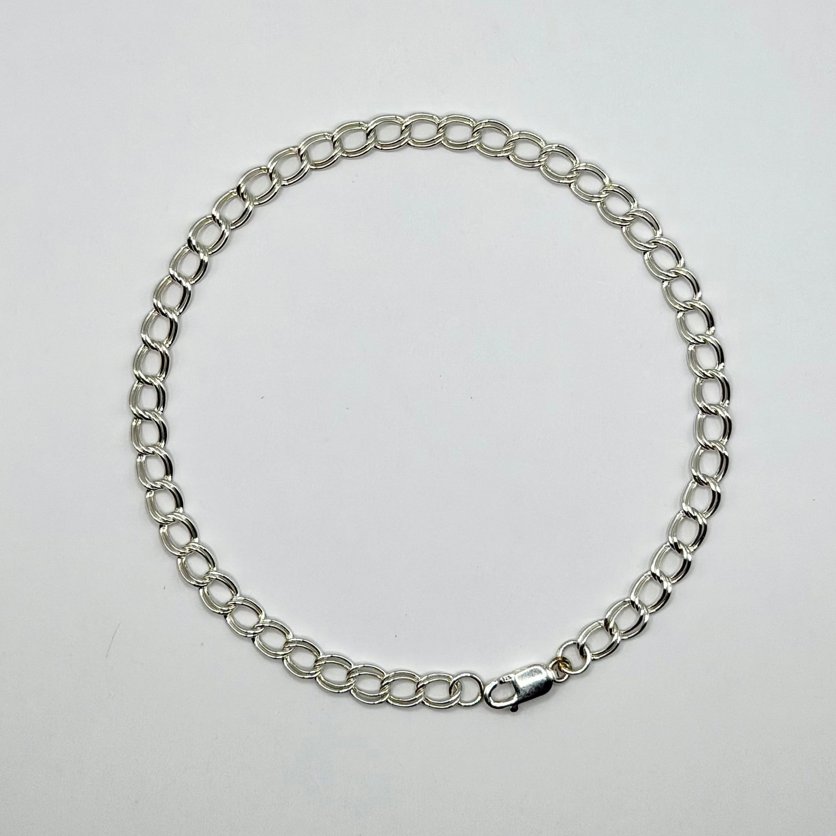 Silver chain bracelet on a light gray background