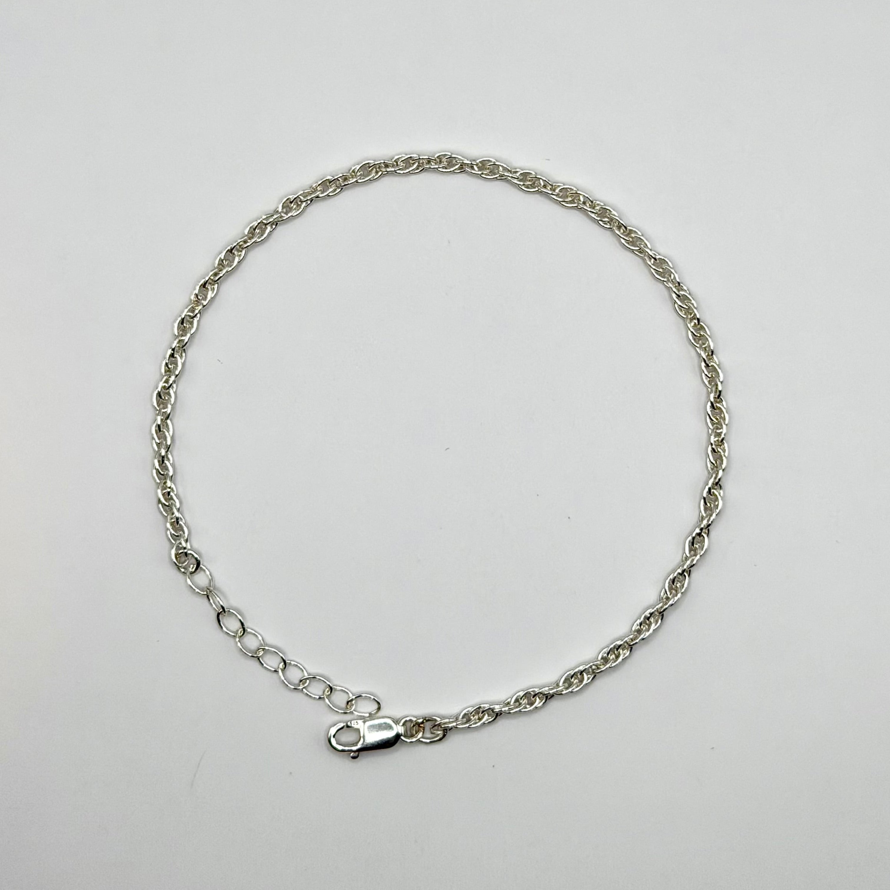 Silver chain bracelet on a light gray background
