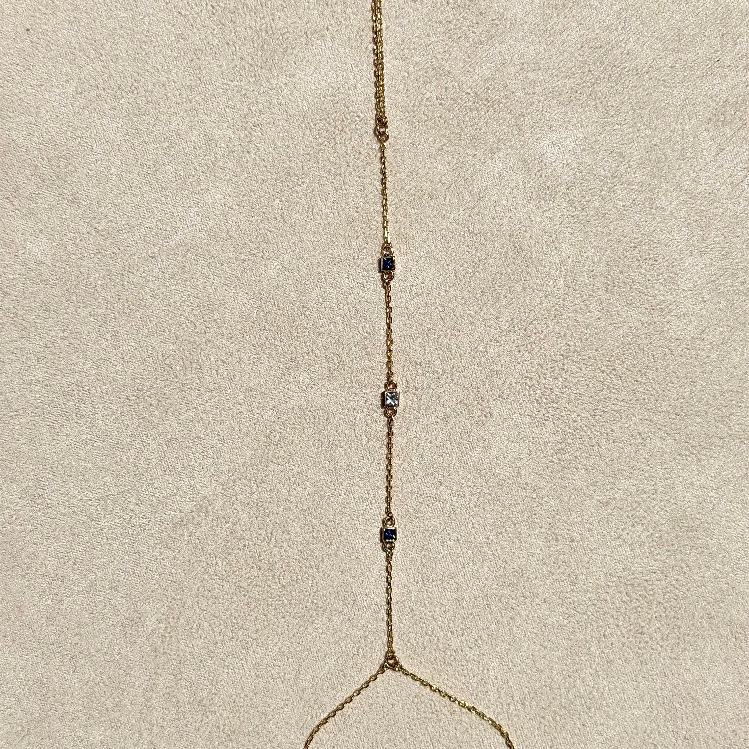 Gold necklace with small beads on a beige cushion