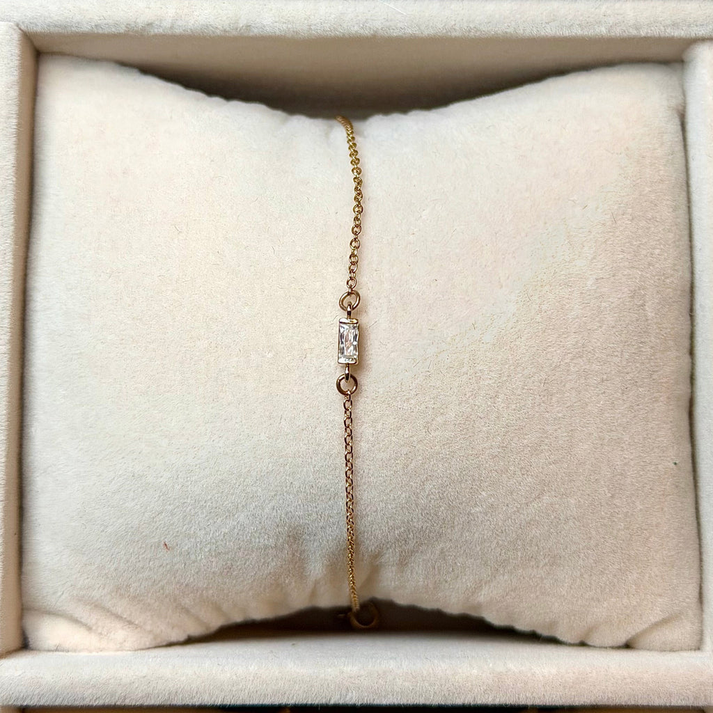Gold bracelet on a cushioned surface in a jewelry box