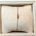 Gold bracelet on a white cushion in a jewelry box